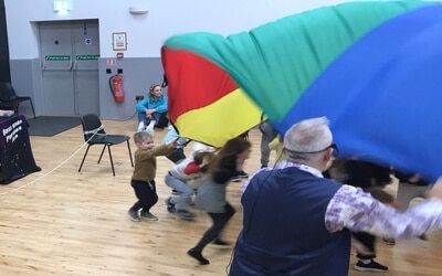 this was a great party idea, kids playing with a giant parachute